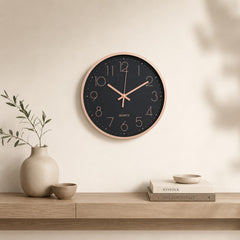 Black and rose gold wall clock above a light wooden console in a calm beige interior
