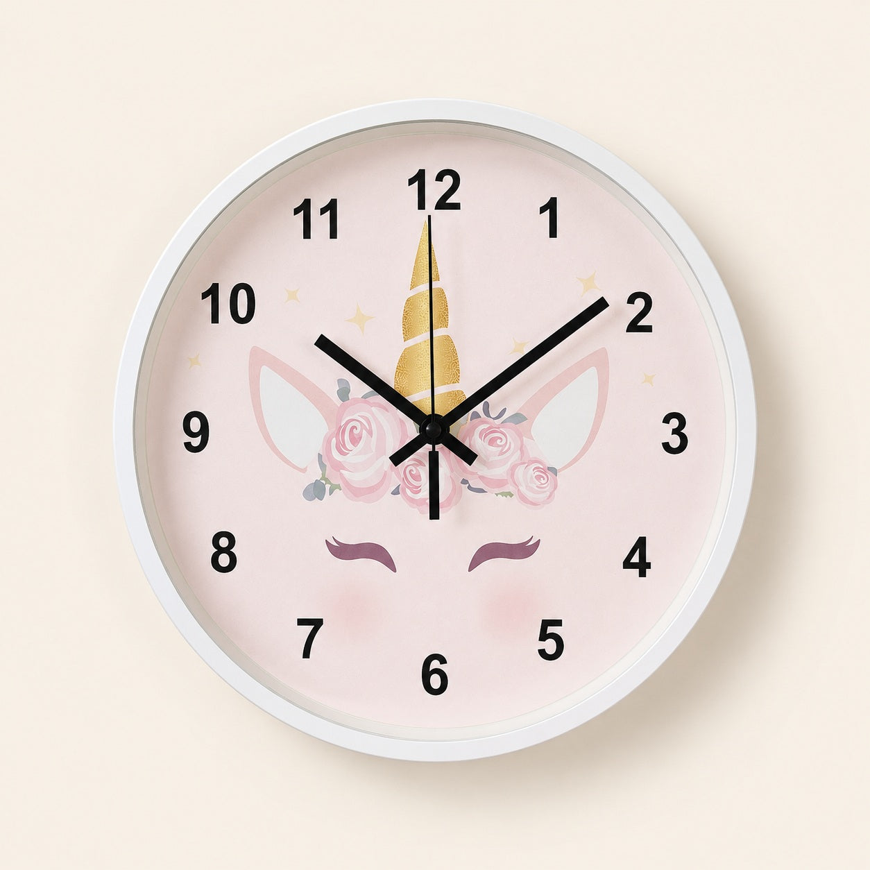 Pink unicorn wall clock with floral details and black numerals on a light beige background