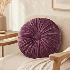 Rindy purple round cushion styled on a beige armchair in a calm living room