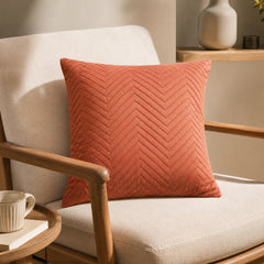 Terracotta chevron cushion styled on a cream sofa in a warm neutral living room