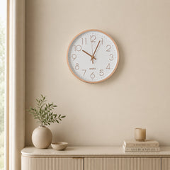 White and rose gold wall clock above a light wooden console in a calm beige interior