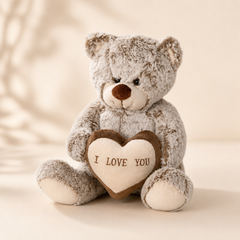 Soft grey plush teddy bear holding heart