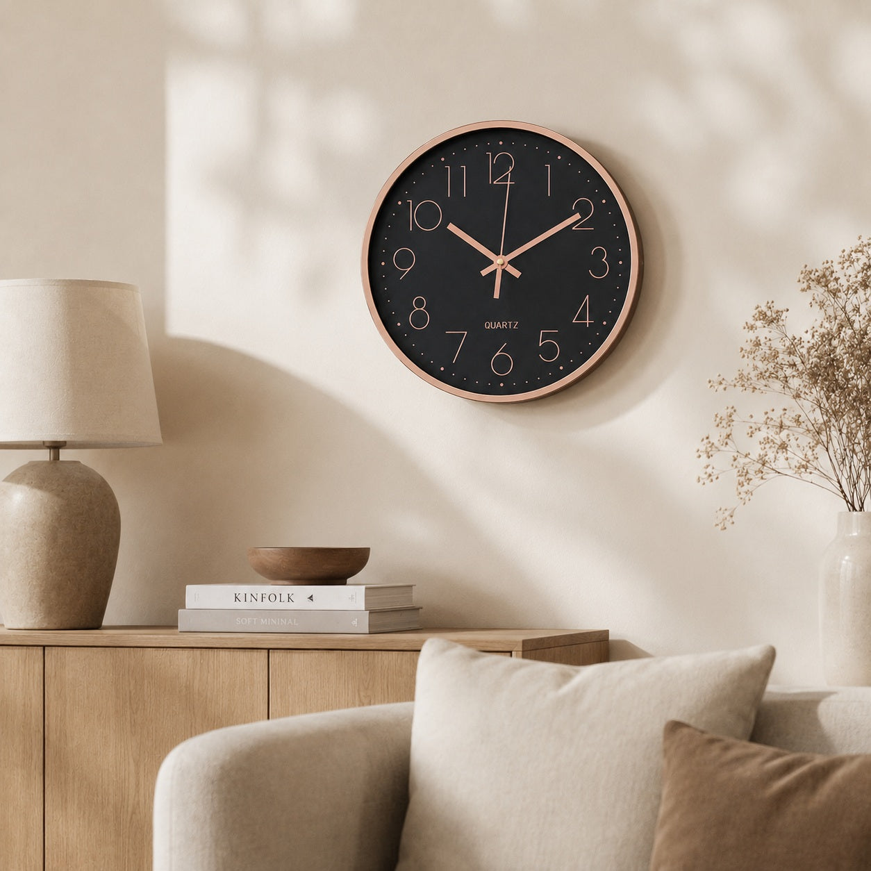 Black wall clock with rose gold rim in a warm neutral living room