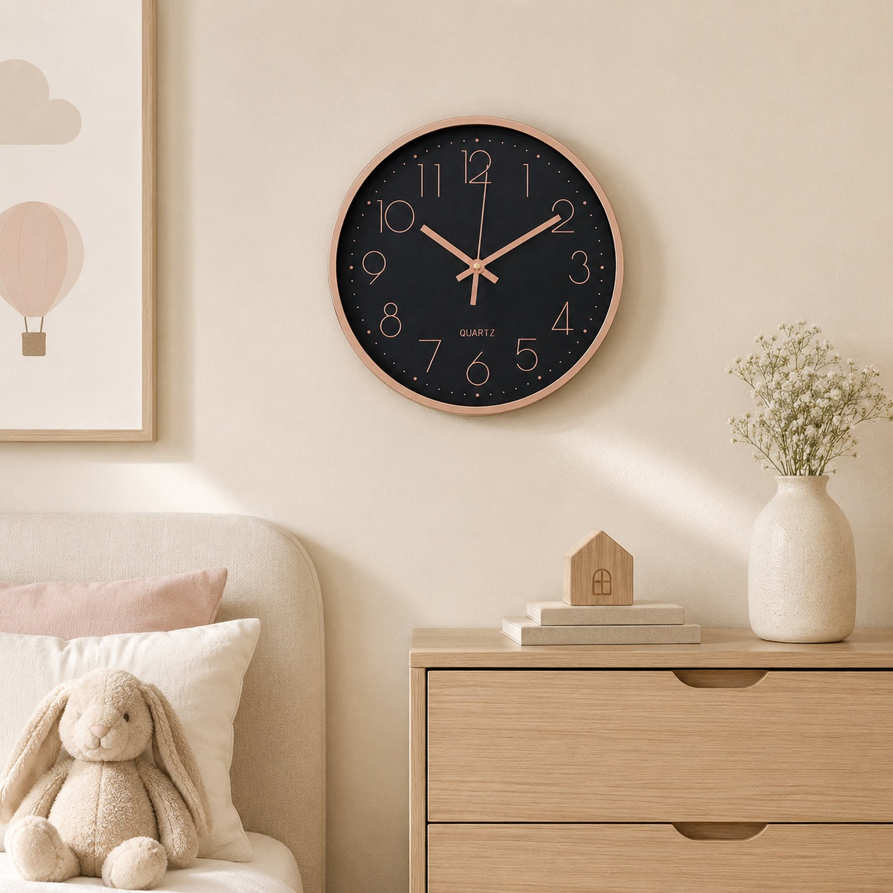 Black and rose gold wall clock in a softly styled children’s room with light wood furniture