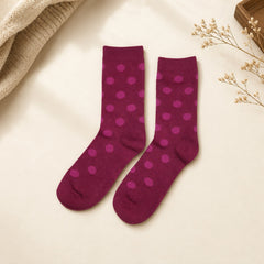 Pink polka dot girls socks and black socks with winking face motif