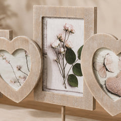 Close-up of beige wooden photo collage frame with heart-shaped openings and distressed finish