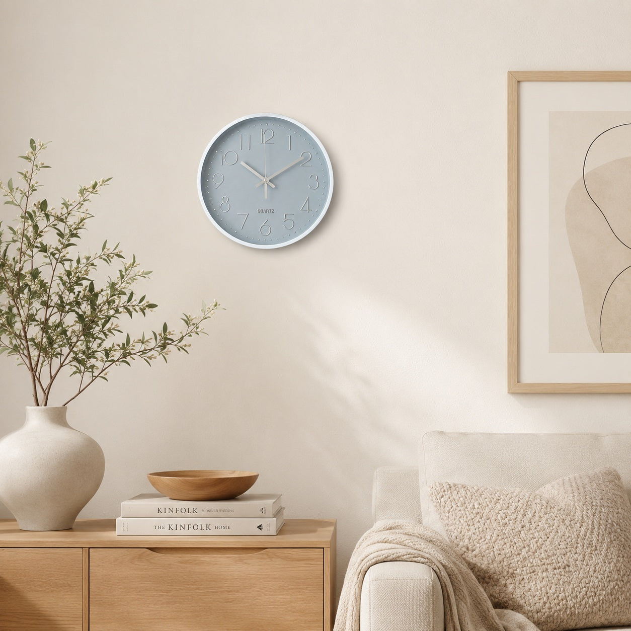 Grey wall clock with white frame in a warm neutral living room