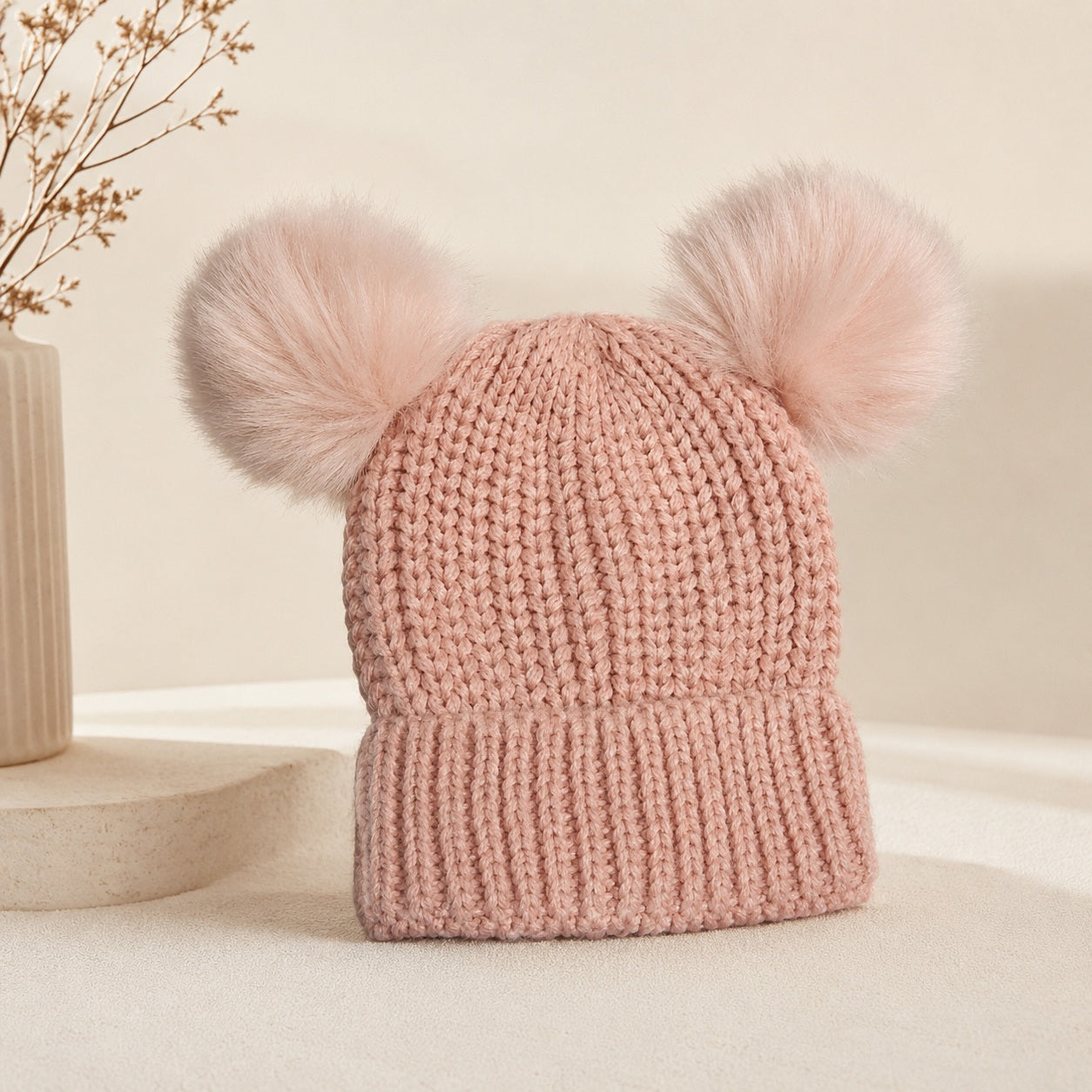 Pink knitted winter hat for kids with fluffy pompoms