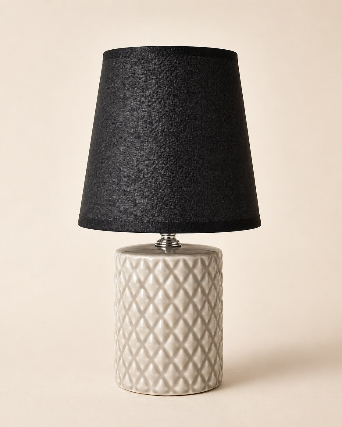 Modern bedside table lamp with black lampshade and beige ceramic base
