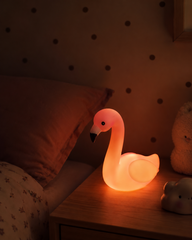 Glowing flamingo night light beside a child’s bed