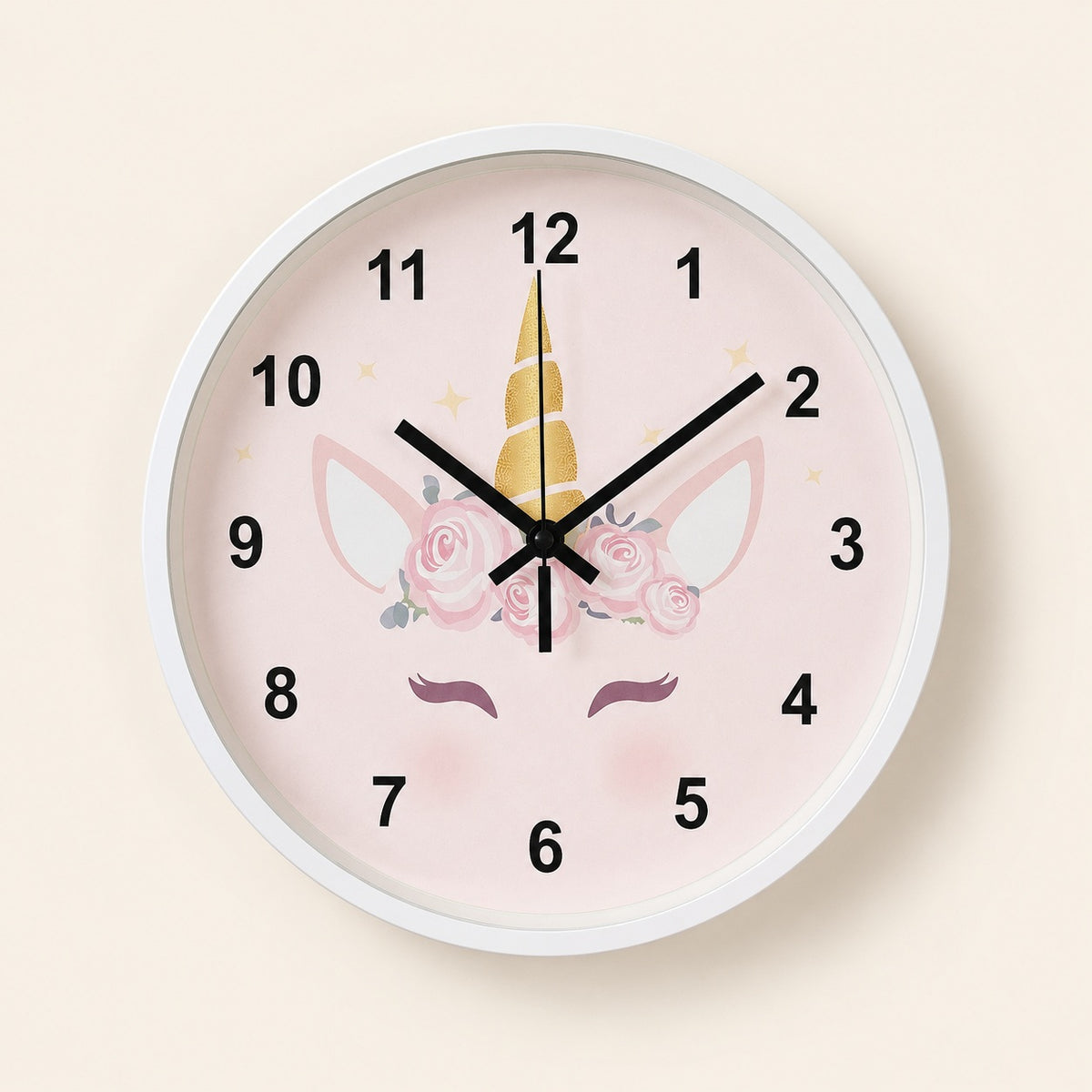 Pink unicorn wall clock with floral details and black numerals on a light beige background
