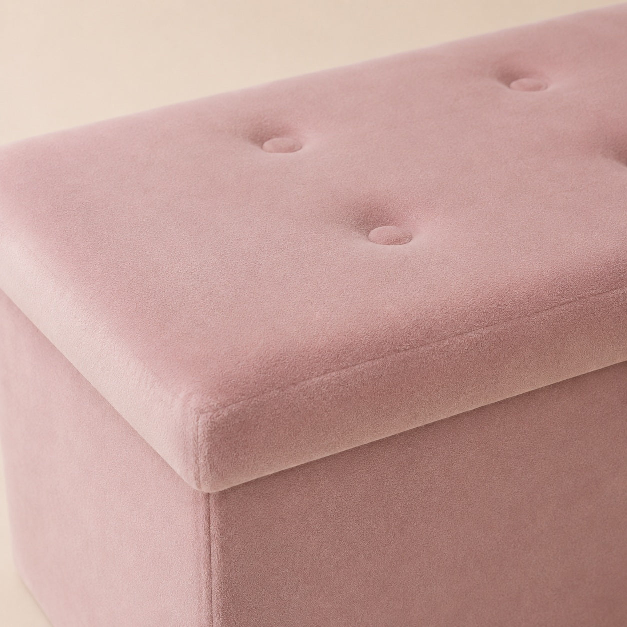 Close-up of pink velvet upholstery and tufted button details