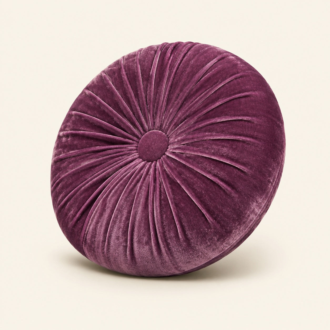 Angled view of Rindy purple round velvet cushion with centre button