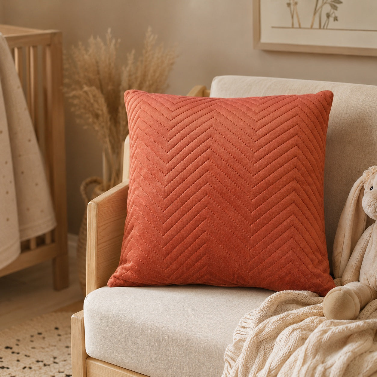 Terracotta velvet cushion in a warm neutral nursery with natural wood details