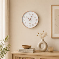 White wall clock with rose gold numerals in a warm Scandinavian-style interior