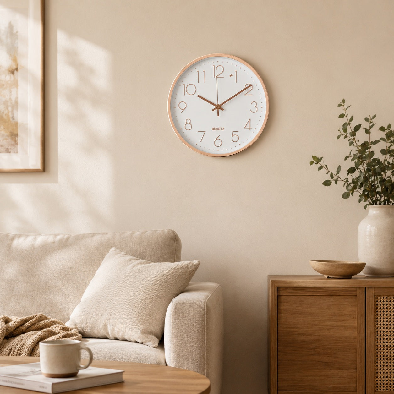 Modern white wall clock with rose gold rim displayed in a neutral living room